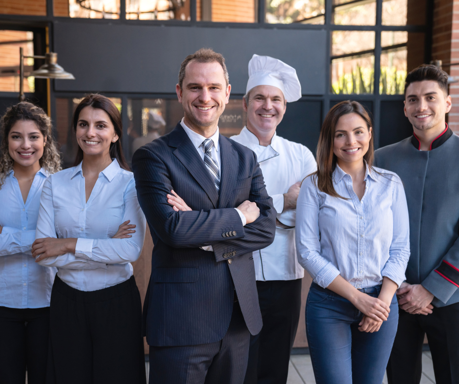 A group of workers smiling in uniforms