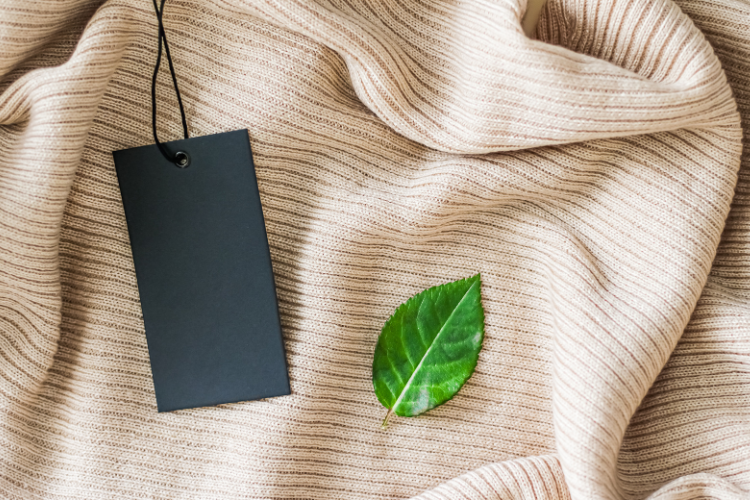 Green leaf on fabric with a tag symbolizing sustainable clothing