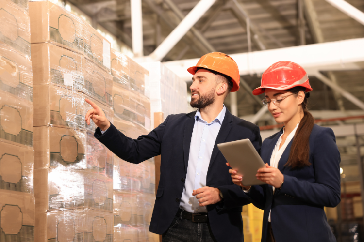 Two managers in suit jackets walking through a warehouse