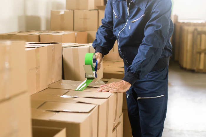 Worker taping a box