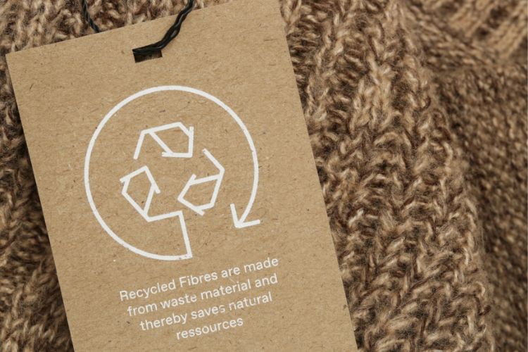 Recycled tag on top of a brown sweater
