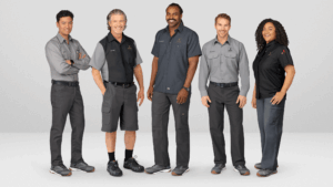 A diverse group of employees wearing well-fitted, professional uniforms and branded apparel, representing a team dressed in high-quality corporate uniforms from a trusted uniform provider.