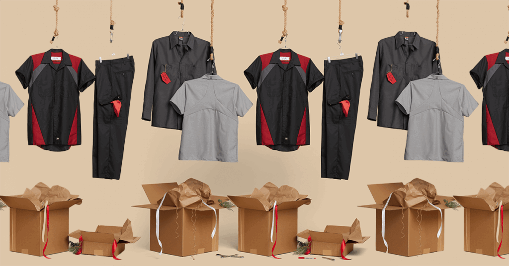 Industrial work uniforms (red, black, and gray shirts) hanging above unsorted cardboard distribution boxes, symbolizing the logistical challenges, hidden administrative labor, and costly overstocking associated with manual uniform inventory management.