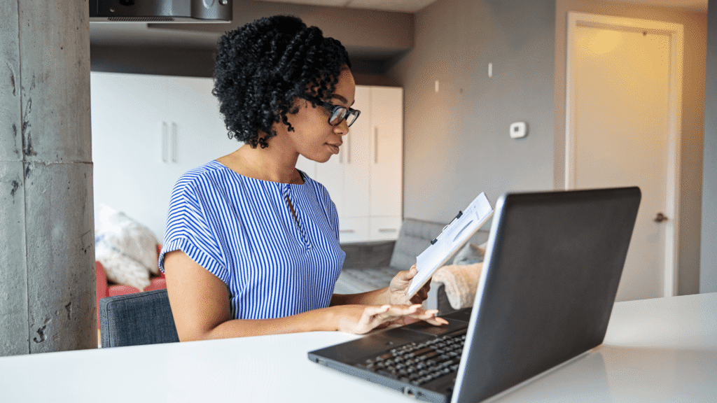 A business manager reviewing a financial report next to a laptop showing a uniform management dashboard to identify hidden operational costs before Tax Day.